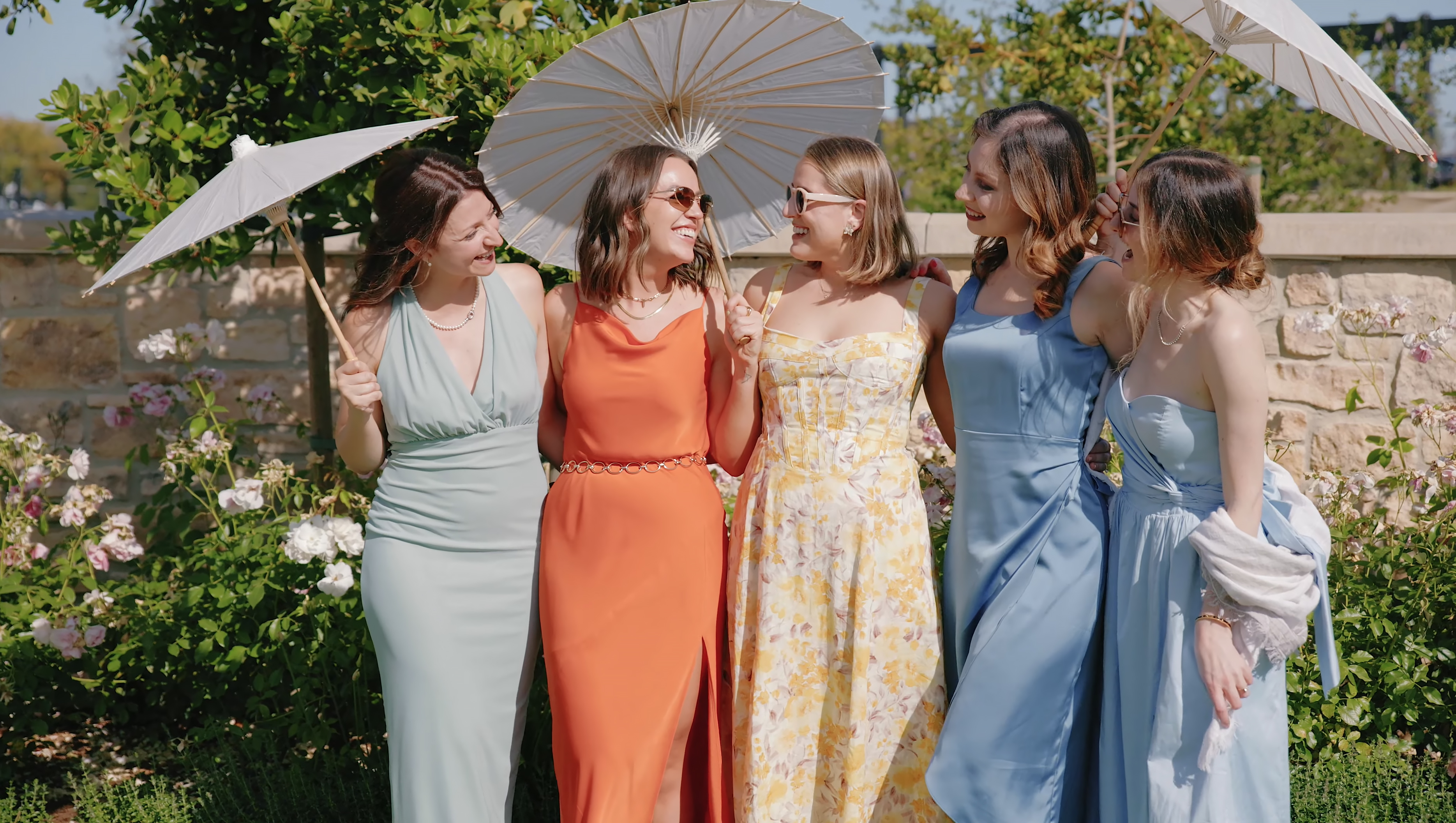 Wedding guests laughing together under parasols at Stanly Ranch