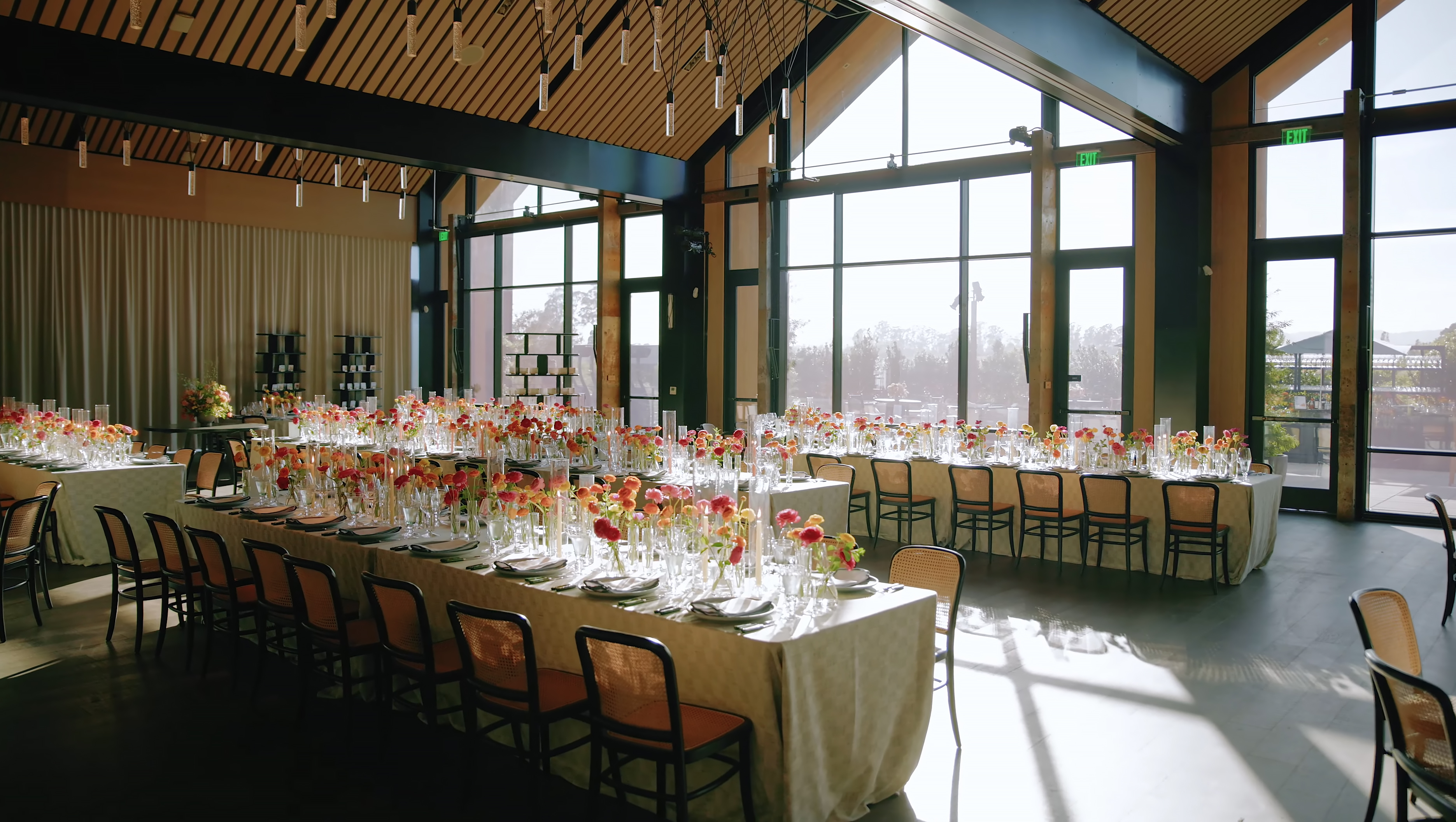 Sunlit Stanly Ranch reception room with long tables and flowers