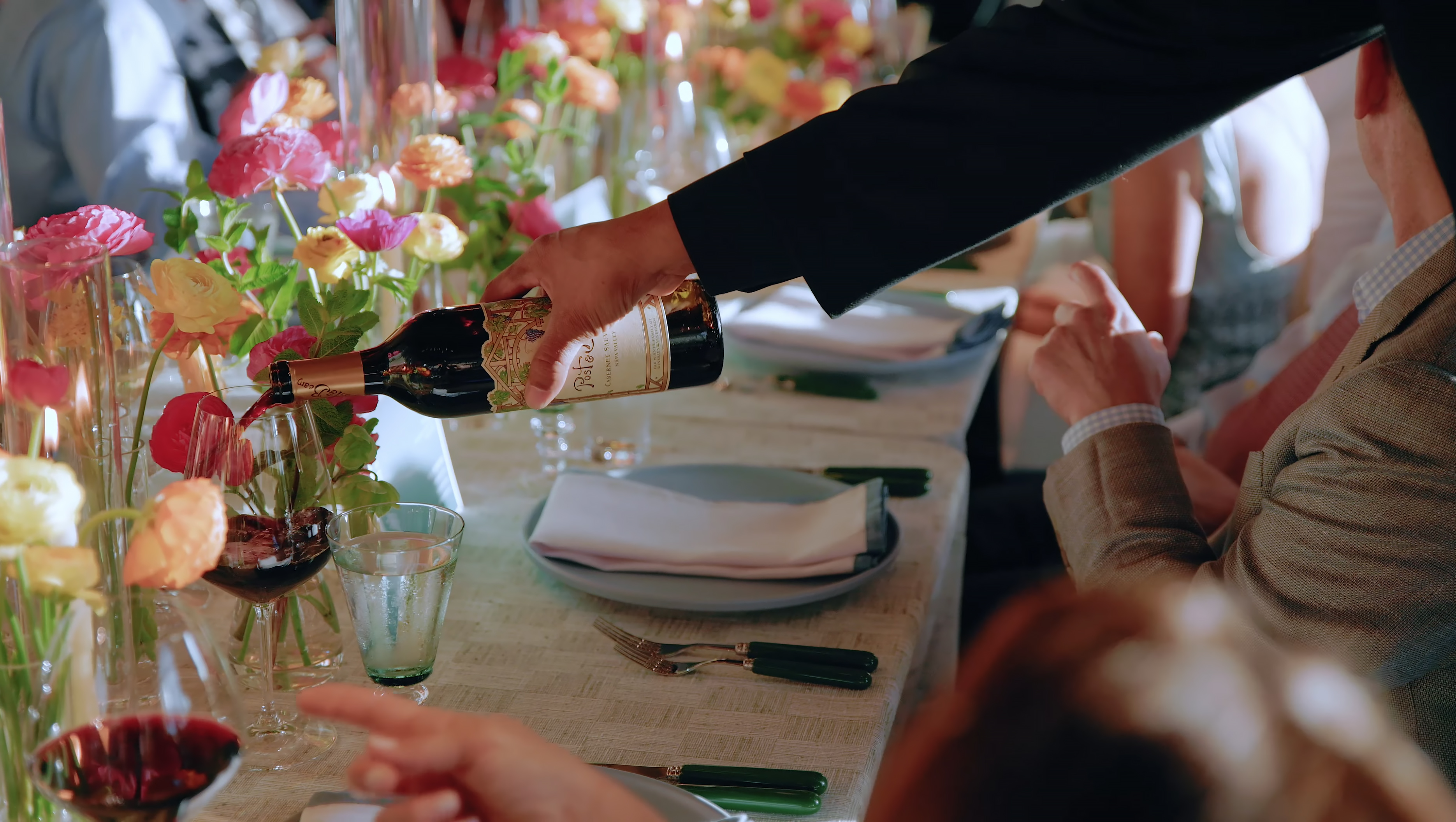 Red wine being poured at a colorful Stanly Ranch dinner table