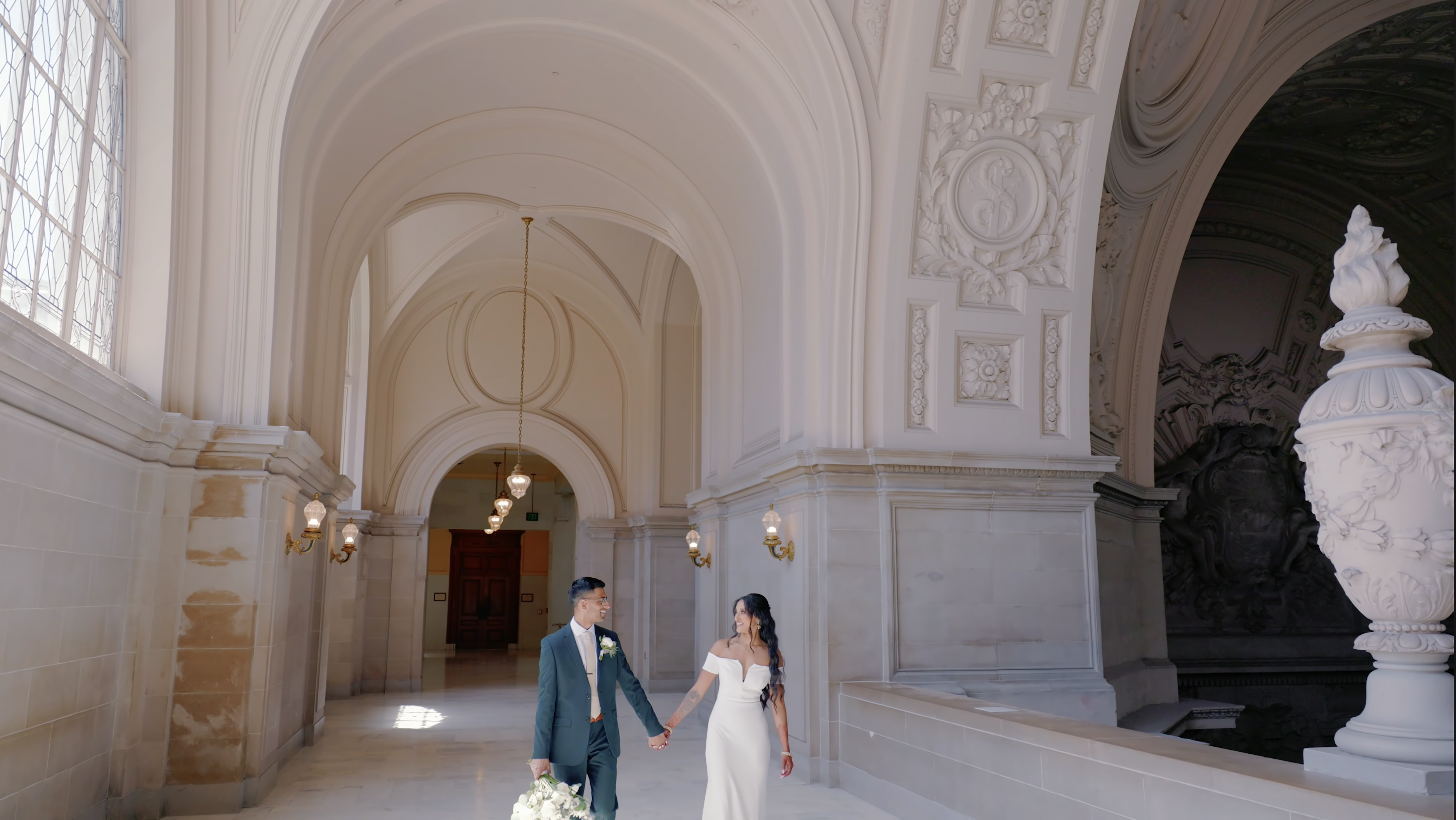 Vini and Jae walking together inside San Francisco City Hall